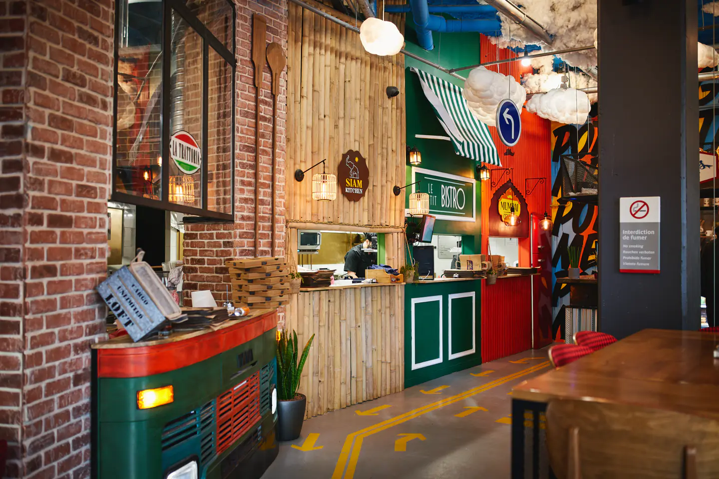Salle du Melting Pot Bagnolet avec briques, bois et comptoirs colorés