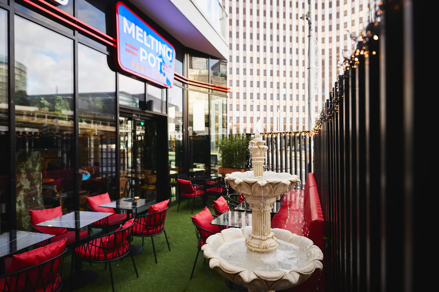 Terrasse du Melting Pot Bagnolet avec sa fontaine et ses chaises rouges