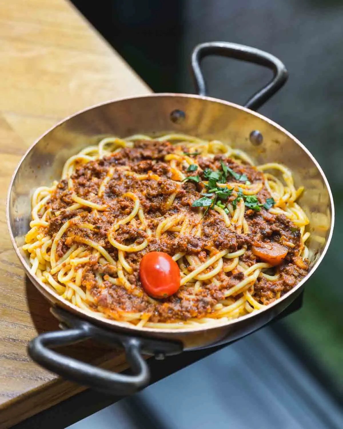 Spaghetti bolognaise servis dans une poêle en cuivre